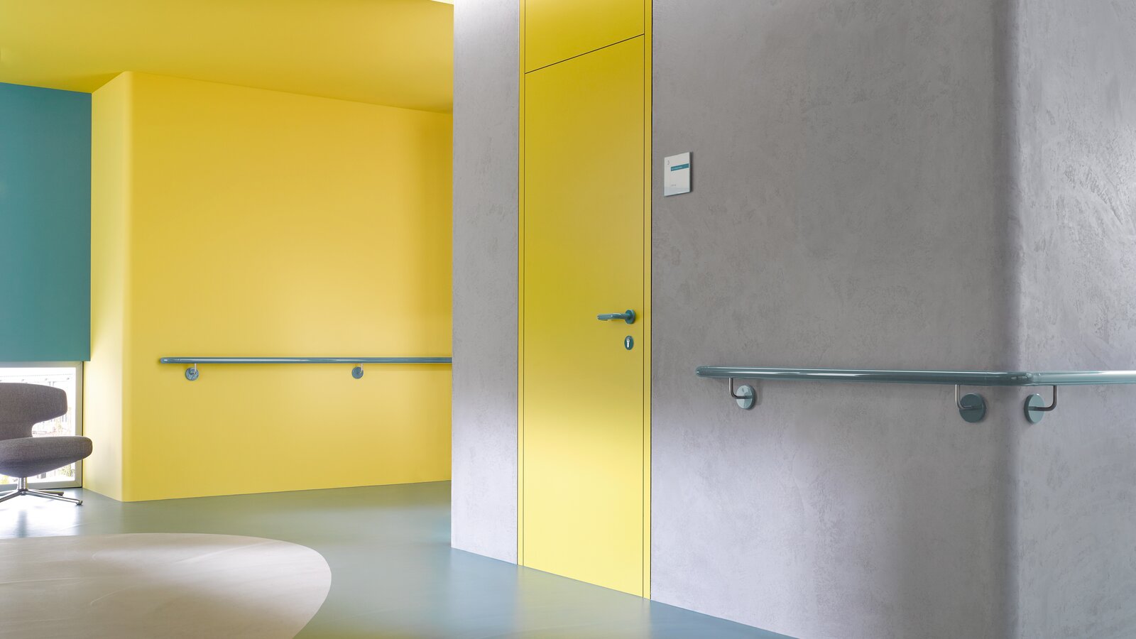 HEWI deurkruk & leuning aquablauw Gele haldeur uitgerust met System 111 deurkruk in aquablauw en handgreep in aquablauw